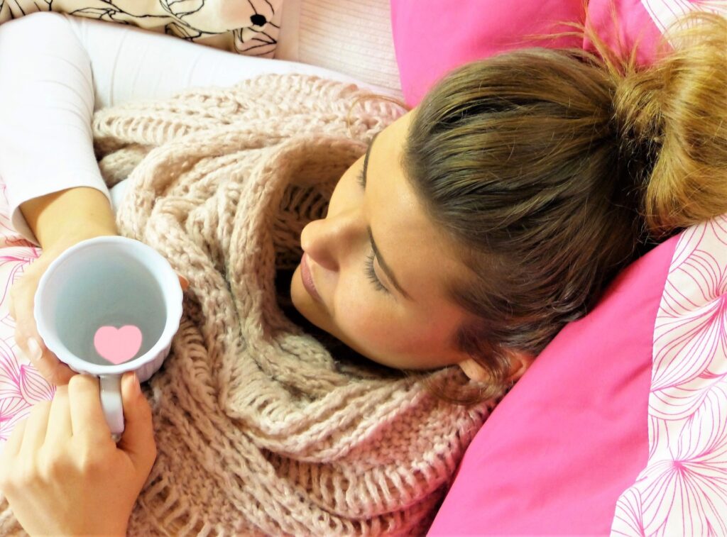Dívka s hrnkem čaje v posteli.