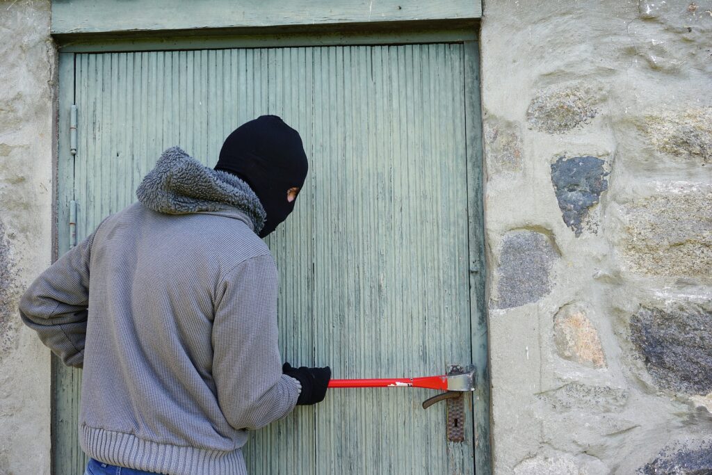 Zloděj se vloupává do dveří.