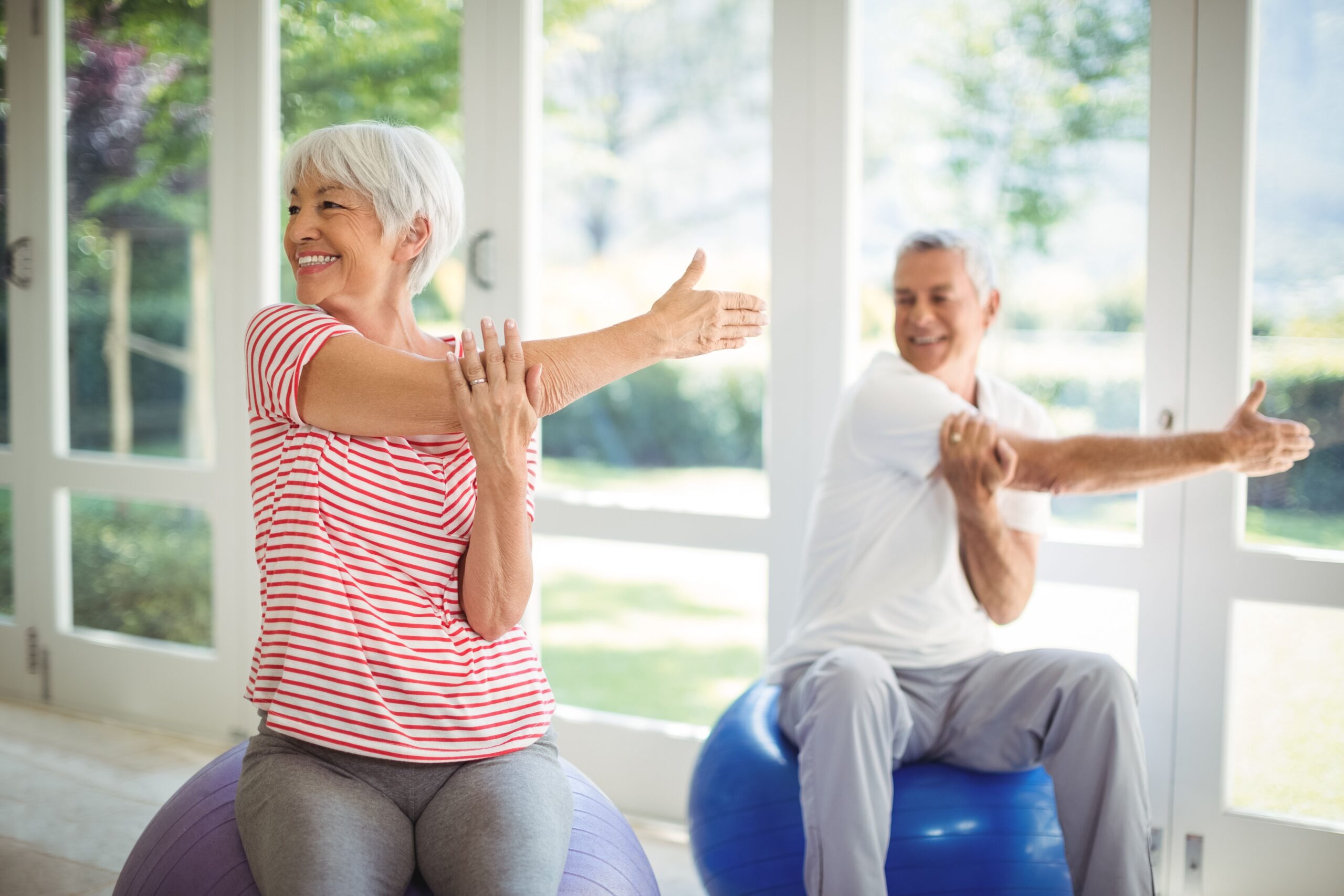 Starší muž a starší žena se protahují před cvičením.
