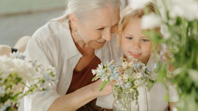 Babička ukazuje vnučce kytky.